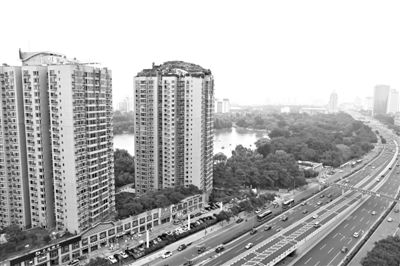 昨日，人濟山莊小區(qū)，與其他樓相比，B棟樓頂層天臺上違規(guī)建造了一棟兩層小樓，假山大樹俱全。新京報記者