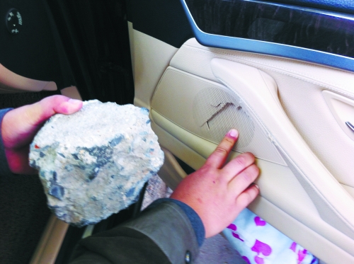 “飛”進(jìn)寶馬車內(nèi)的大石塊,將寶馬車的車門內(nèi)飾板砸爛。