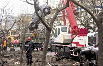 輸油管道爆炸后，搶修人員將被炸毀的車輛運(yùn)出現(xiàn)場。
