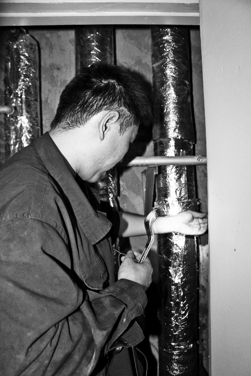 苗師傅一邊進(jìn)行維修，一邊用耳機(jī)接聽市民的電話。