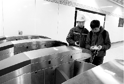 昨天上午，體育中心站，工作人員正在對進出站閘機進行調(diào)試。