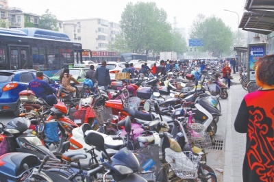 省人民醫(yī)院北門(mén)，路邊的公交站牌處停滿(mǎn)非機(jī)動(dòng)車(chē)，上、下客只能在快車(chē)道上。