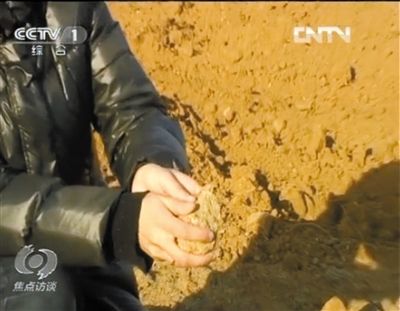 麻剛沙系麻剛石粉碎而成。記者找到一塊麻剛石，一捏就碎成粉末，硬度非常差。央視截圖