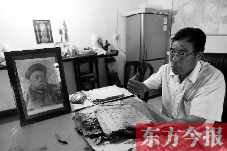 　魏樹紹手拿《物權(quán)法講義》手稿，在講訴先祖書寫“物權(quán)法”的歷史（相框里就是魏聯(lián)奎）