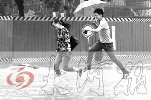 鄭州經(jīng)三路與北環(huán)交叉口處，積水較深，行人們不得不“練輕功”。 記者 白周峰 攝影