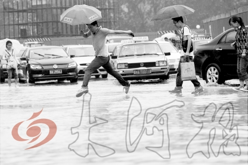 鄭州經(jīng)三路與北環(huán)交叉口處，積水較深，行人們不得不“練輕功”。 記者 白周峰 攝影