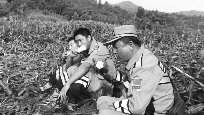 饑餓難忍，中國(guó)緊急救援河南基地的救援隊(duì)員在已毀的玉米地里撿拾生玉米吃。