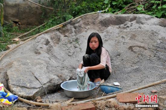 8月9日，云南巧家紅石巖村，10歲的劉鑫蕊在洗自己的衣服