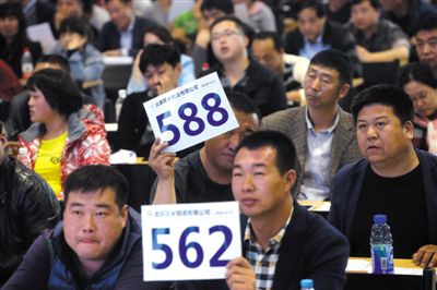 昨日，拍賣現(xiàn)場競拍者舉牌競拍。新京報記者