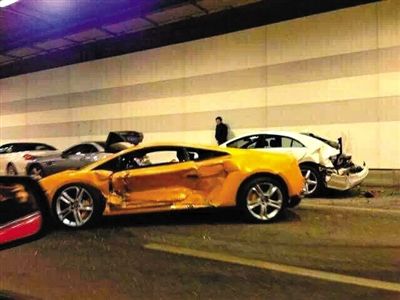 一目擊者出示照片，隧道內(nèi)，事發(fā)時還停著多輛車，其中一輛黃色豪車車門明顯內(nèi)凹，另一白色車車尾損毀嚴重。