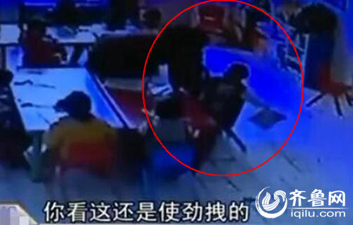 孩子上課時(shí)被老師拖拽。（紅圈中拿書者系孩子）