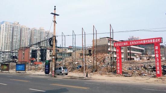 015年5月31日，在社區(qū)干部的帶頭拆遷下，親賢社區(qū)的“城中村改造”拉開帷幕。由于前期“清產(chǎn)核資”及補(bǔ)償標(biāo)準(zhǔn)等因素，拆遷改造工作推進(jìn)并不順利。圖為位于體育西路東側(cè)集體所有的商鋪率先被拆遷完畢，用于遮擋的圍擋正在施工中。（拍攝：2015年9月16日）