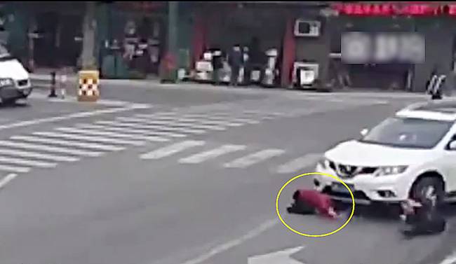 圖為小姑娘被卷進車輪下瞬間。