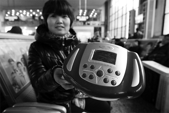 火車站候車室，李女士向記者展示她準(zhǔn)備孝敬父母的按摩儀