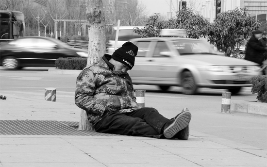 2月2日，鄭州市中州大道農(nóng)業(yè)路立交橋下，50歲的王文德打算在臨近春節(jié)前再接些零活兒，由于疲憊，他睡著