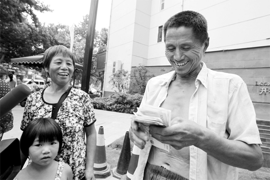 昨日，鄭州市明達(dá)路與豐慶路交叉口西300米路南，來自中牟的瓜農(nóng)拿到西瓜款，笑開顏東方今報(bào)記者袁曉強(qiáng)