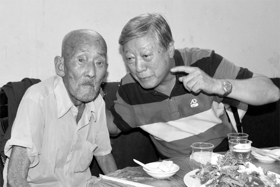 昨日，來自北京的英雄后代胡冠軍（右）專門趕到西平縣看望抗戰(zhàn)老兵孫殿修老人