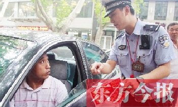 交警為車主講解“挪車請(qǐng)撥打114轉(zhuǎn)車主”的提示牌的使用方法