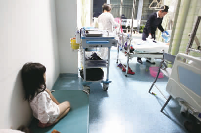 嘟嘟一早就醒了，小小的身體靠在墻邊看著爸爸進行手術(shù)前準備