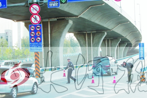 交警在東風(fēng)路從北向南上橋口處擺上反光錐，間歇放行
