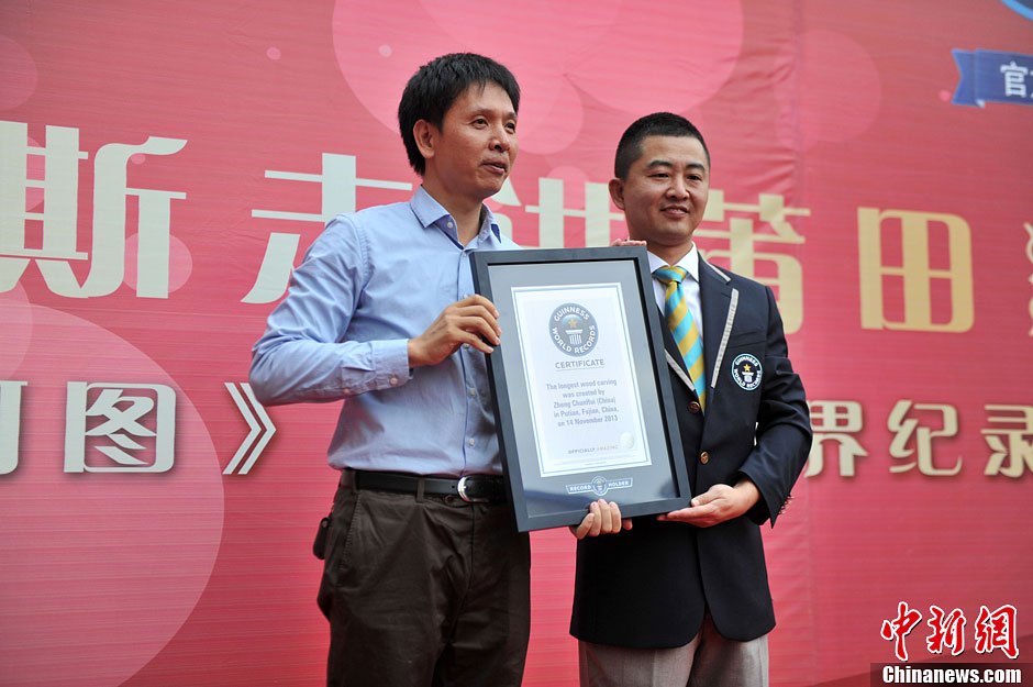 圖為世界吉尼斯認證官為鄭春輝（左）頒發(fā)證書。呂明 攝