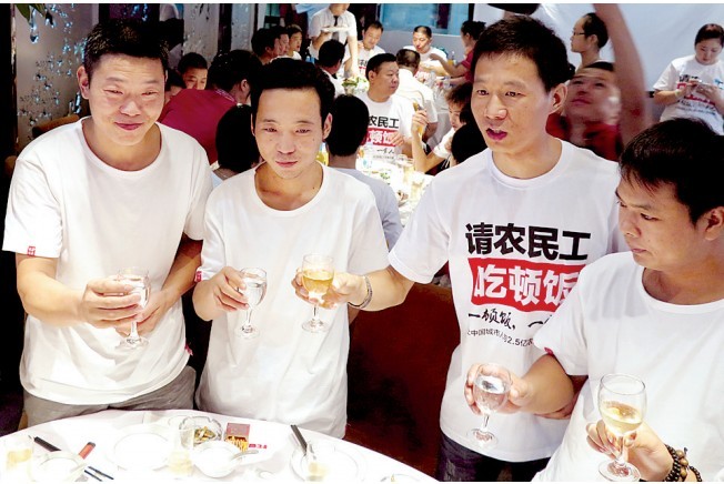活動(dòng)發(fā)起人張楠（右二）給農(nóng)民工敬酒。