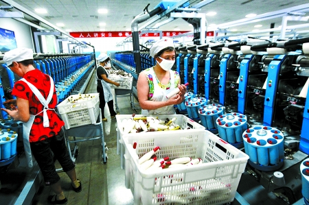 6月6日，舞鋼市鑫海紡織有限公司員工正在新建成的紡紗車間生產(chǎn)。