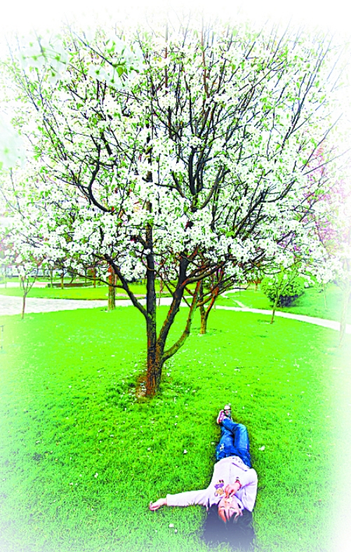 　孩子愜意地躺在社區(qū)內(nèi)的草坪上。