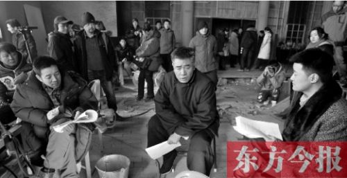 導(dǎo)演安建（左）、主演陳寶國(guó)等坐在一起說(shuō)戲