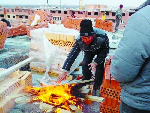 在俄羅斯工地打工時(shí)，因?yàn)樘焯?，工人不得不在工地生火取暖。（圖由方先生提供）