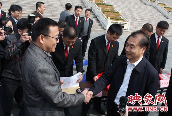 在新密市法院，省高院院長張立勇為拍得轎車的陳先生發(fā)放車鑰匙。