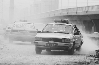 施工的道路上，車輛通過塵土飛揚。