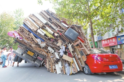 紅色小轎車(chē)被砸，卡在路邊動(dòng)彈不得。