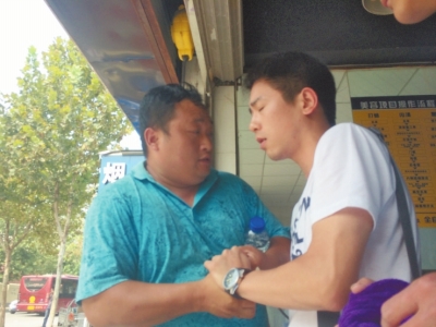 記者正查看照片，突遭藍(lán)衣男強(qiáng)搶手機(jī)。