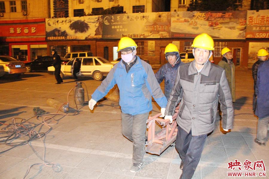 23點56分，第一塊兒廣告牌已經(jīng)分割完畢，地面上的20多名工人將拆除下來的鋼件撞車運走。