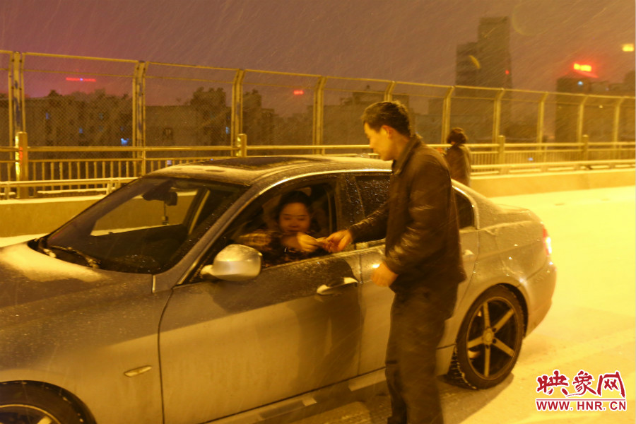 “推車人”幫助一輛車上坡后，收取“勞務(wù)費(fèi)”。