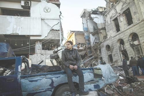 埃及曼蘇拉市警察局24日遭汽車炸彈襲擊，被疑是穆兄會的報復。圖為一名男子在被炸毀的警察局前。