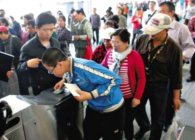 去年5月5日，14號(hào)線園博園站，乘客刷卡出地鐵。北京公交地鐵將實(shí)行計(jì)程票制，多乘坐多付費(fèi)。