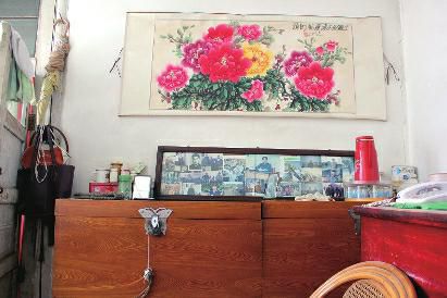 　陳會(huì)英將兒女的照片都裱起來，裝在一個(gè)大相框里，放在箱子上經(jīng)?？?，其中最多的就是劉金國(guó)的照片。