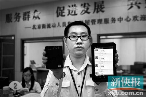 　越秀區(qū)北京街出租屋外來暫住人員管理服務(wù)中心的工作人員展示到出租屋登記來穗人員信息的儀器。