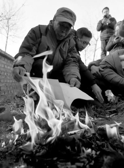 李三仁在兒子墳前焚燒再審無罪判決文書的復(fù)印件。新華社發(fā)