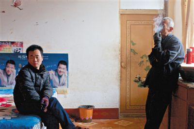 父親抽煙，兒子不語。逃跑的越南新娘，給袁迎賓父子帶來的是失落。新京報記者