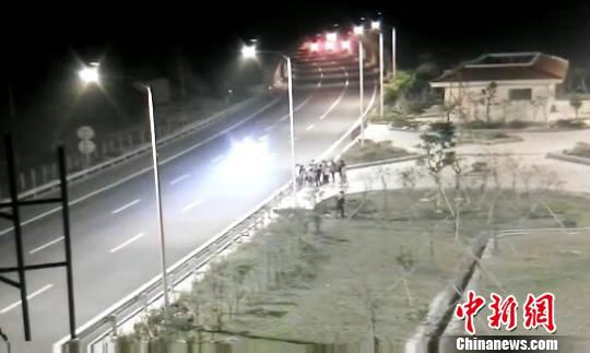 看到車輛經(jīng)過，孩子們便急忙跑到一旁的花圃上?！【焦﹫D　攝