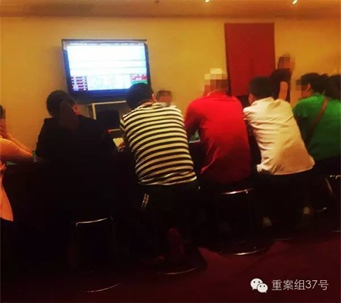 賭客圍坐在賭桌前 賭客圍坐在賭桌前