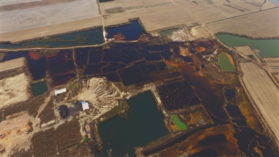 4月19日，廊坊市大城縣南趙扶鎮(zhèn)，津保路以北約八九百米處，一個巨大的污水坑中，水體呈現(xiàn)紅褐色。 新京報記者 尹亞飛 攝