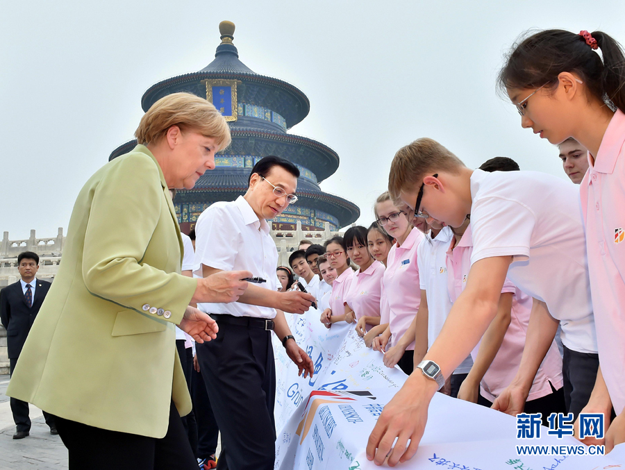 李克強同默克爾在紀(jì)念橫幅上簽名。