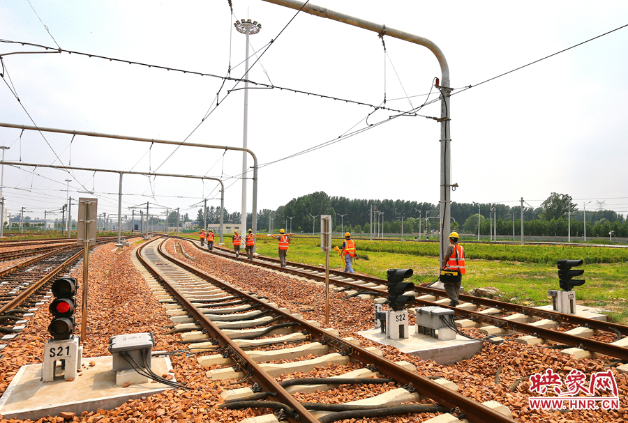 在太陽的直射下，檢修工人扛著沉重的設(shè)備向施工地點出發(fā)