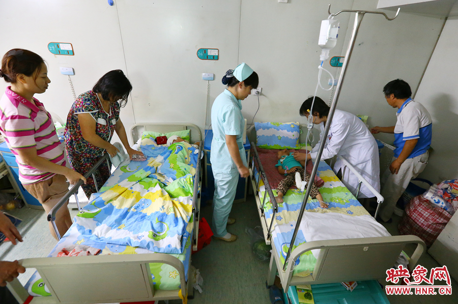 手術(shù)前，畫面右側(cè)的大龍正在接受醫(yī)生的檢查，左側(cè)的小龍還在熟睡。