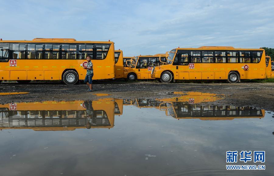 8月29日，溫嶺市城西街道芷勝莊村一名小男孩從閑置的校車邊走過(guò)。