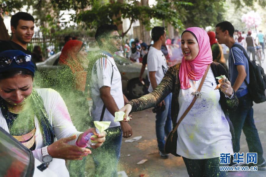 10月16日，在埃及首都開羅，一名女青年在“彩色跑”活動(dòng)中拋撒彩色粉末。
